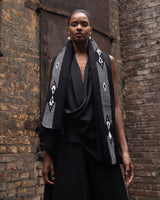 Model wearing the Arrows Edge Wrap, showcasing its design and texture against a brick background.