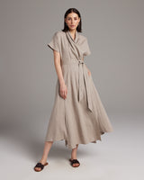 Model wearing a taupe Butterfly Wrap Dress in Linen, showcasing its flow and design.