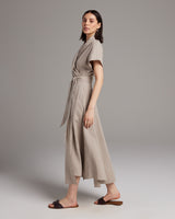 Model wearing a taupe Butterfly Wrap Dress made of linen, showcasing its flowing silhouette.