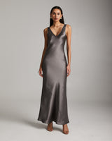 Model wearing a long double V slip dress in silver mink, showcasing its elegant drape.
