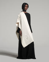 Model wearing the Estrella Shawl in ivory with geometric patterns