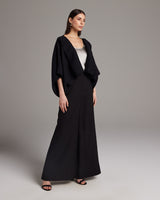 Model wearing a black hand-loomed Jungle Bolero over a silk tank and wide trousers.