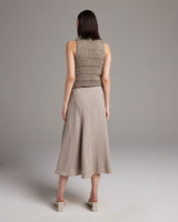 Model wearing a sleeveless top and a flowing linen skirt from the back