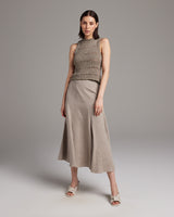 Model wearing a knit top and linen skirt in taupe color
