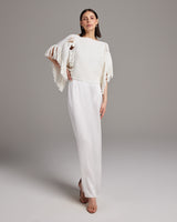 Model wearing a white Lace Fringe Crop Top with fringe sleeves and a long skirt