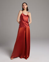 Model wearing a silk tank top and palazzo pants in a rich tomato color