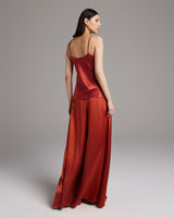 Model wearing a silk tank top and palazzo pants in red, viewed from the back