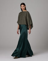 Model wearing a green top and flowing silk palazzo pants