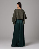 Model wearing a green silk palazzo pants with a stylish top, showcasing the back view.