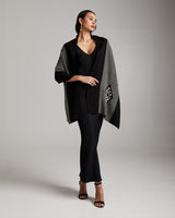 Model wearing the Estrella Shawl in black and grey, standing against a neutral background.