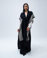 Model wearing a black and cream striped edge caftan, styled with a belt.