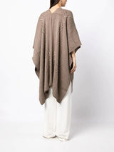 Model wearing a brown Raíz Duster with geometric patterns on the back