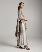 Model wearing a solid alpaca duster in beige with satin pants and heels.