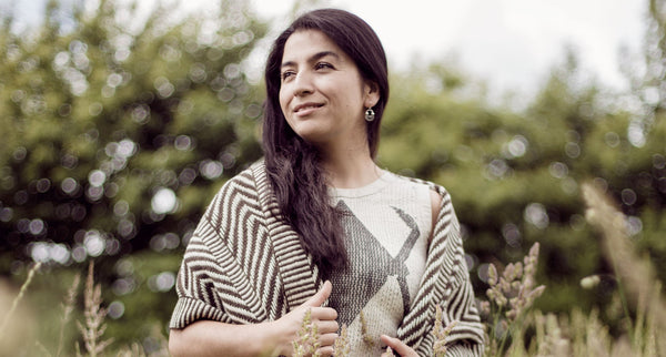 Yessica Huenteman Medina standing outdoors in a field, wearing a patterned shawl.