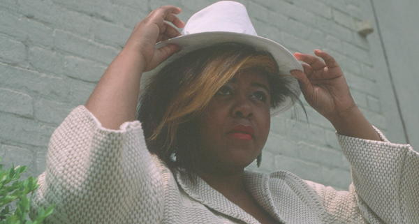 Chana Ewing wearing a white hat, posing outdoors