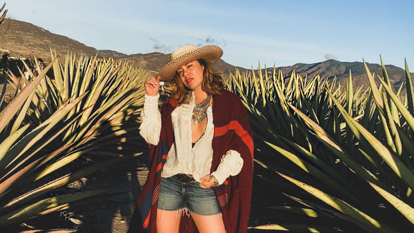 Grace Ramirez wearing a hat and shawl in an agave field
