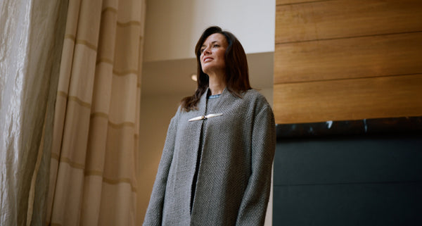 Blythe Masters wearing a grey cardigan, standing indoors with natural light