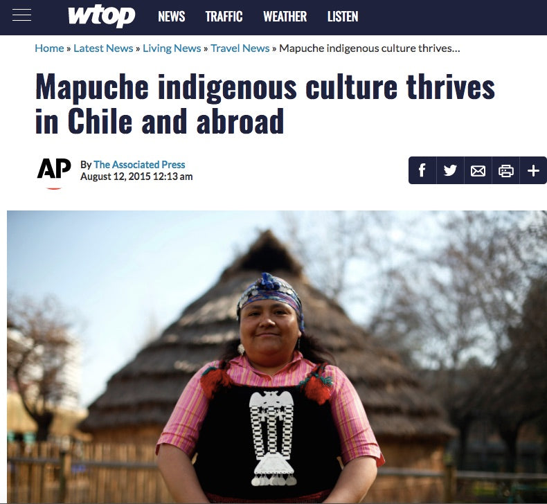 A Mapuche woman in traditional attire stands in front of a thatched hut, representing indigenous culture in Chile.