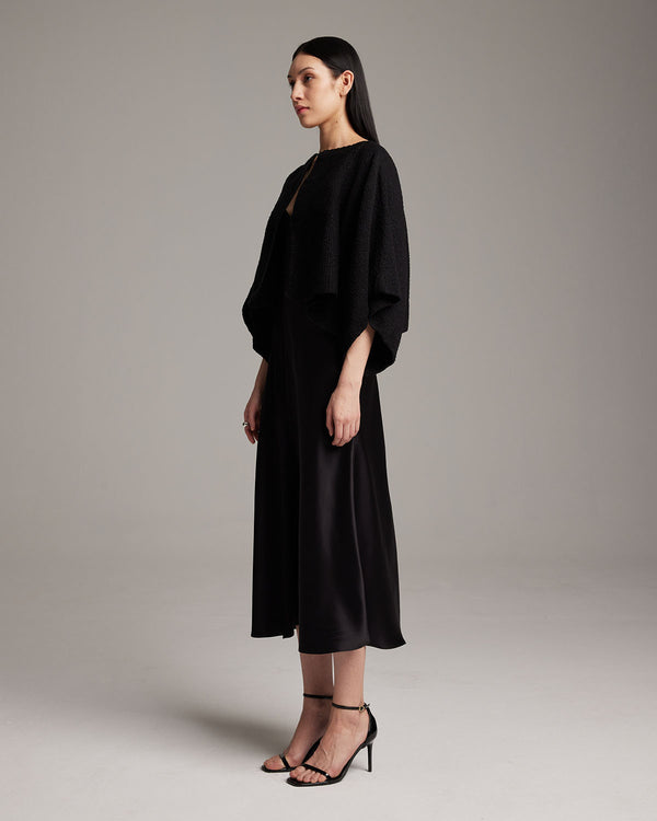Model wearing a black textured cotton bolero over a black dress