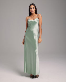 Model wearing a sage green liquid silk slipdress