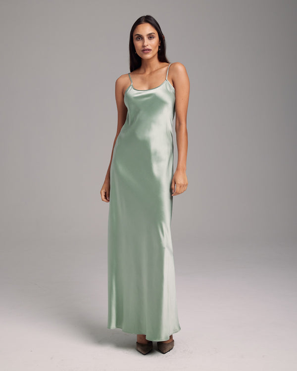 Model wearing a sage green liquid silk slipdress