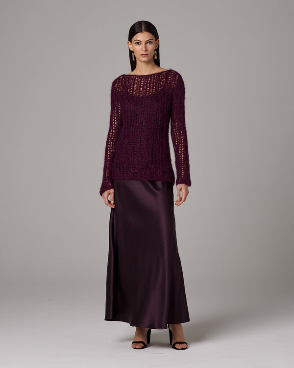 Model wearing a burgundy Open Mesh Boatneck Sweater over a satin skirt