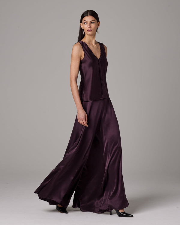 Model wearing silk palazzo pants in dark purple, showcasing the flowing design.