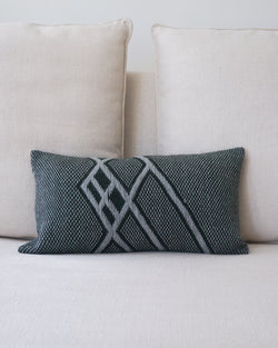 Che Lumbar Pillow in Forest Green with geometric pattern on a light sofa