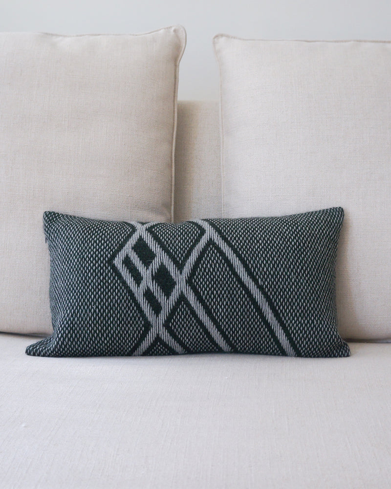 Che Lumbar Pillow in Forest Green with geometric pattern on a light sofa