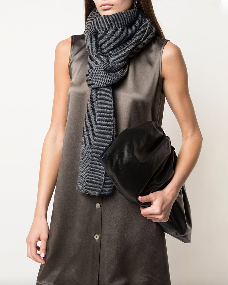 Model wearing a grey Chevron scarf, holding a black clutch
