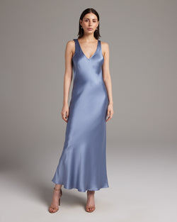 Model wearing a blue Double V Slip Dress in silk charmeuse, showcasing its elegant drape and V-neck design.