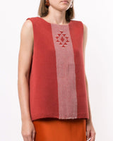 Model wearing a brick-colored sleeveless Estrella V-Back Top with a geometric design.