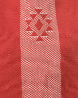 Close-up of the Estrella V-Back Top fabric showing a red and white pattern with the Estrella symbol.