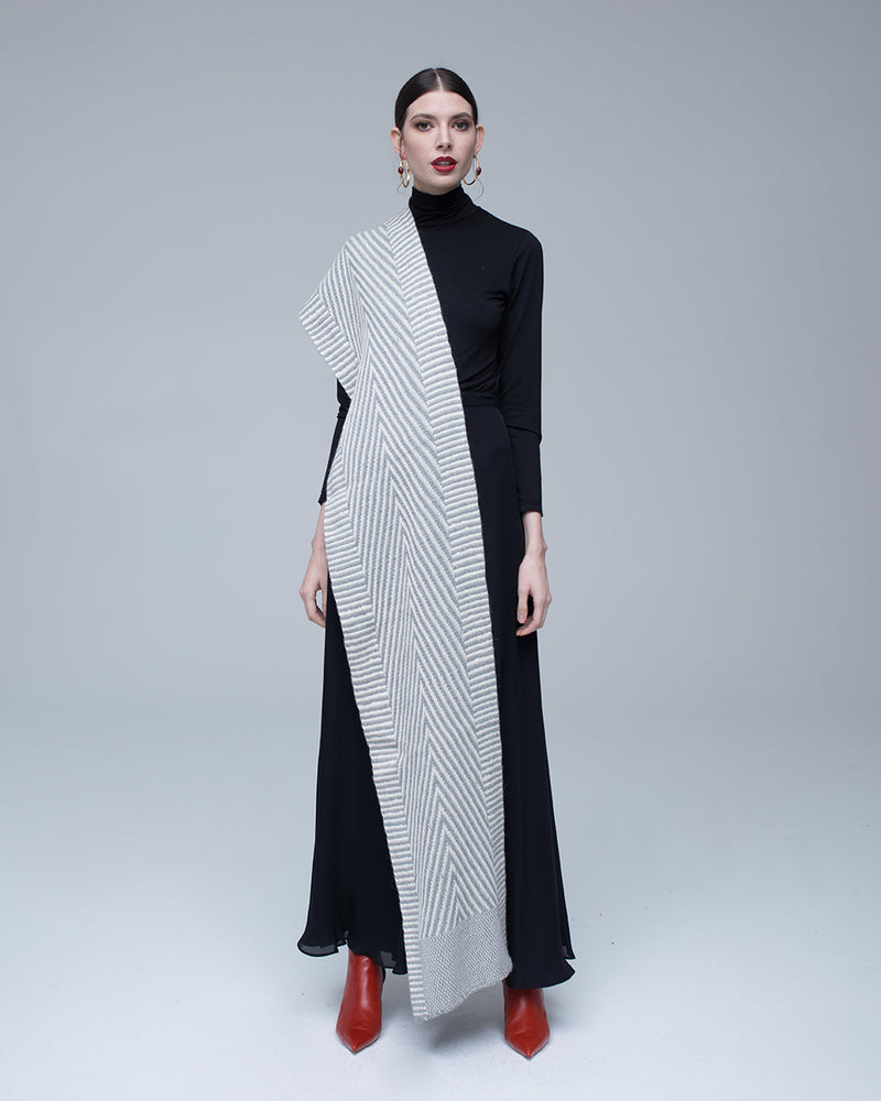 Model wearing a Chevron scarf in light gray over a black dress with red shoes