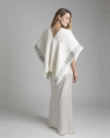 Model wearing a hand-loomed ivory linen manta with grey detailing on edges