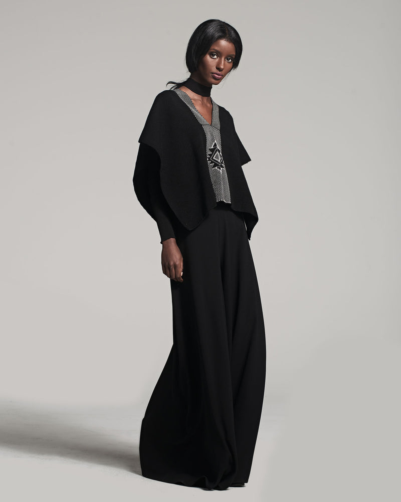 Model wearing Manta Estrella poncho with Estrella symbol design